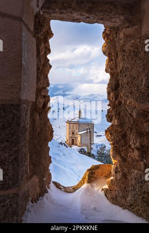 Winterblick auf die Renaissancekirche Santa Maria della Pieta mit Schnee vom Schloss Rocca Calascio aus Stockfoto