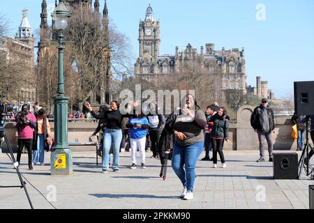 Edinburgh, Schottland, Großbritannien. 8. April 2023 RCCG Edinburgh Tabernacle Chor singt mit Gusto und unterhält Urlauber und Besucher im The Mound mit dem Balmoral Hotel als Kulisse. Kredit: Craig Brown/Alamy Live News Stockfoto