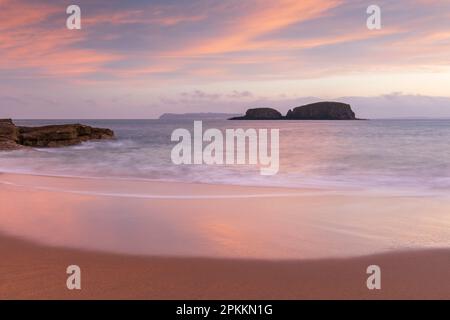 Sonnenaufgang über Sheep Island von den Sandstränden von Secret Beach bei Ballintoy im Herbst, County Antrim, Ulster, Nordirland, Vereinigtes Königreich Stockfoto