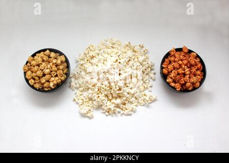 Aromatisiertes Popcorn: Natürlich, mit Chili und Karamell, eine Auswahl an Snacks mit Getränken, die für einen Film bereit sind Stockfoto