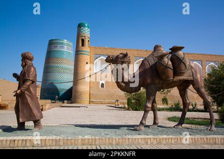 Skulptur des Kamelzugs, Kalta Minaret im Hintergrund, Ichon Qala (Itchan Kala), UNESCO-Weltkulturerbe, Khiva, Usbekistan, Zentralasien, Asien Stockfoto