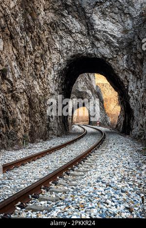 Alte Eisenbahn durch kurze Tunnel in malerischer ländlicher Landschaft Stockfoto