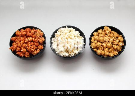 Aromatisiertes Popcorn: Natürlich, mit Chili und Karamell, eine Auswahl an Snacks mit Getränken, die für einen Film bereit sind Stockfoto