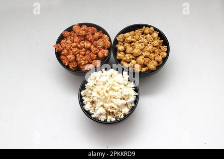 Aromatisiertes Popcorn: Natürlich, mit Chili und Karamell, eine Auswahl an Snacks mit Getränken, die für einen Film bereit sind Stockfoto