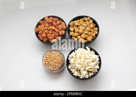 Aromatisiertes Popcorn: Natürlich, mit Chili und Karamell, eine Auswahl an Snacks mit Getränken, die für einen Film bereit sind Stockfoto