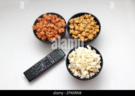 Aromatisiertes Popcorn: Natürlich, mit Chili und Karamell, eine Auswahl an Snacks mit Getränken, die für einen Film bereit sind Stockfoto