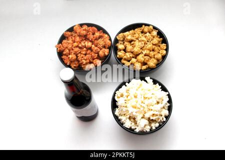 Aromatisiertes Popcorn: Natürlich, mit Chili und Karamell, eine Auswahl an Snacks mit Getränken, die für einen Film bereit sind Stockfoto