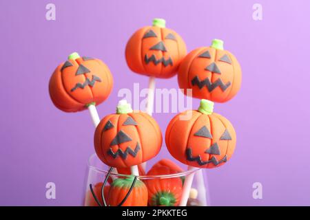 Köstlicher Kürbiskuchen auf violettem Hintergrund, Nahaufnahme. Halloween-Leckerbissen Stockfoto