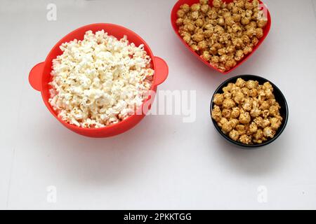 Aromatisiertes Popcorn: Natürlich, mit Chili und Karamell, eine Auswahl an Snacks mit Getränken, die für einen Film bereit sind Stockfoto