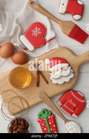 Köstliche Weihnachtskekse und Zutaten auf weißem Holztisch, flach liegend Stockfoto