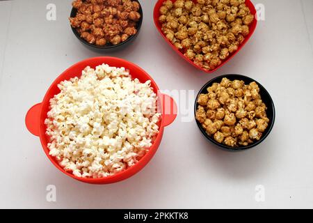 Aromatisiertes Popcorn: Natürlich, mit Chili und Karamell, eine Auswahl an Snacks mit Getränken, die für einen Film bereit sind Stockfoto