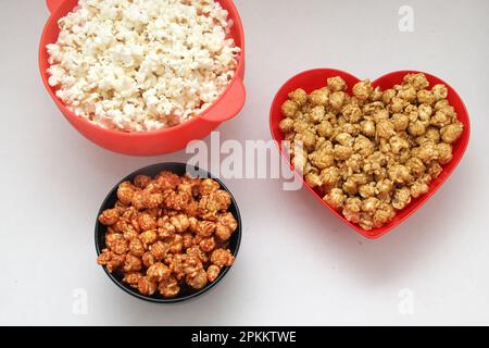 Aromatisiertes Popcorn: Natürlich, mit Chili und Karamell, eine Auswahl an Snacks mit Getränken, die für einen Film bereit sind Stockfoto