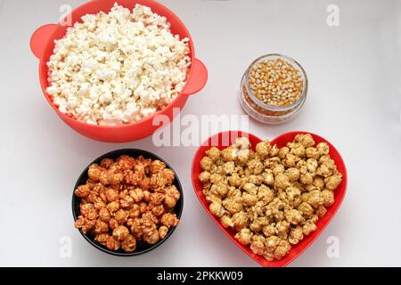 Aromatisiertes Popcorn: Natürlich, mit Chili und Karamell, eine Auswahl an Snacks mit Getränken, die für einen Film bereit sind Stockfoto