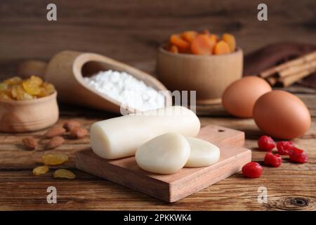 Marzipan und andere Zutaten für hausgemachtes Stollen auf einem Holztisch. Traditionelles deutsches Weihnachtsbrot backen Stockfoto