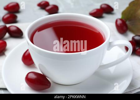 Eine Tasse frischer Hundeholztee und Beeren auf dem Tisch, Nahaufnahme Stockfoto