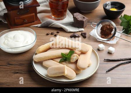 Leckere Kekse und andere Zutaten für Tiramisu auf einem Holztisch Stockfoto