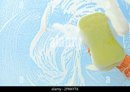 Person, die Glas mit Schwamm reinigt, Sicht von innen Stockfoto