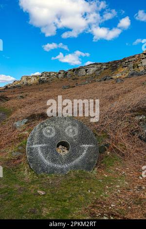 Smiley-Gesicht, das an alten verlassenen Mühlsteinen in Stanage Edge, einer Gritstone-Klippe im Peak District, Derbyshire, England, zerkratzt ist Stockfoto