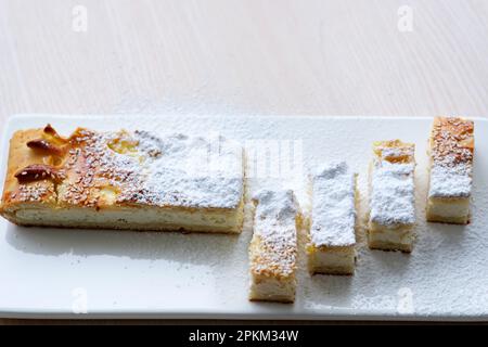 Auf weißem Porzellanbrett köstliches Dessert mit Puderzucker Platz für Text auf hausgemachtem Gebäck, Quark aus Käse und Hefe Stockfoto