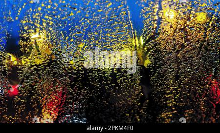 Farbabstraktion. Unscharfer Fokus. Blick durch Milchglas auf die Lichter der Stadt bei Nacht Stockfoto