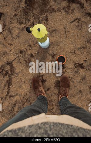 Person, die im Herbst auf einem Campingplatz Kaffee zubereitet Stockfoto