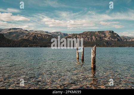 Baumstämme in einem Fluss mit Blick auf die Berge mit Wolken Stockfoto