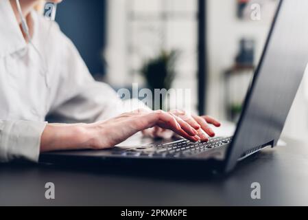 Frauenhand beim Tippen auf der Tastatur. Stockfoto