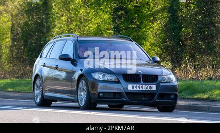 2006 grauer BMW der 3-Serie, der auf einer englischen Landstraße fährt Stockfoto