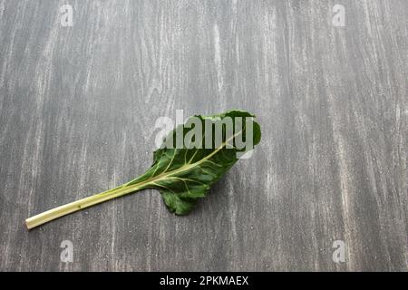 Frisch geerntete große grüne Mangold Blätter bereit zum Zerkleinern und Kochen nahrhafter und gesunder omido auf einem Holztisch Stockfoto