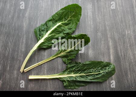 Frisch geerntete große grüne Mangold Blätter bereit zum Zerkleinern und Kochen nahrhafter und gesunder omido auf einem Holztisch Stockfoto