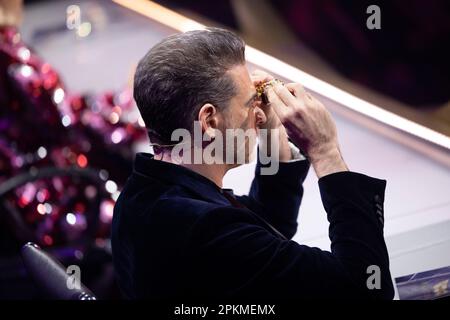 Köln, Deutschland. 08. April 2023. Rategast Rick Kavanian, Schauspieler und Komiker, sitzt am Ratespiel und sieht durch die Opernbrille in der ProSieben-Show "The Masked Singer". Kredit: Thomas Banneyer/dpa/Alamy Live News Stockfoto