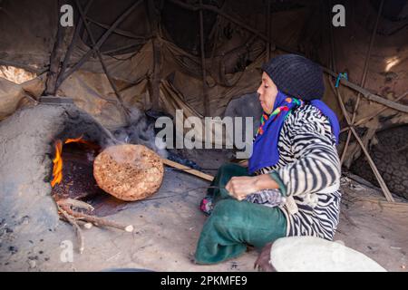 Eine marokkanische Frau kocht eine Berber-Pizza in einem Holzofen Stockfoto