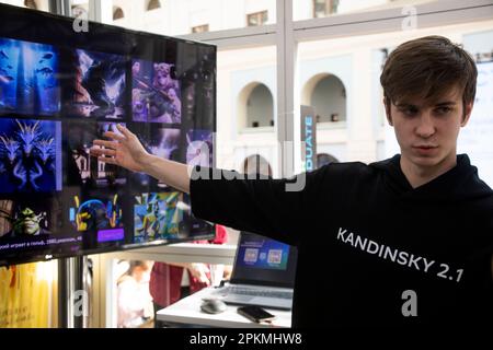 Moskau, Russland. 8. April 2023. Ein junger Mann präsentiert das neuronale Netzwerk Kandinsky 2,1 (künstliche Intelligenz für die Bilderzeugung) auf der internationalen Fachmesse für intellektuelle Literatur „Non/Fiction Spring“ im Messezentrum Gostiny Dvor in Moskau, Russland Stockfoto