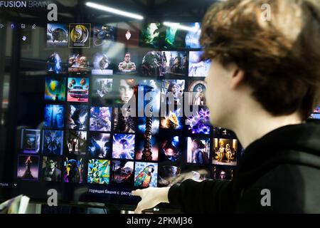 Moskau, Russland. 8. April 2023. Ein junger Mann präsentiert das neuronale Netzwerk Kandinsky 2,1 (künstliche Intelligenz für die Bilderzeugung) auf der internationalen Fachmesse für intellektuelle Literatur „Non/Fiction Spring“ im Messezentrum Gostiny Dvor in Moskau, Russland Stockfoto