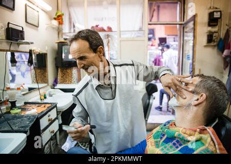 Ein amerikanischer Tourist, der sich in einem Friseursalon in Marrakesch Marokko rasiert Stockfoto