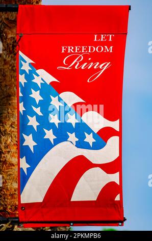 Ein patriotisches Banner hängt am 2. April 2023 an einer Palme in Gulfport, Mississippi. Das rote Banner ist mit den Worten eingraviert: "Lasst die Freiheit klingeln." Stockfoto