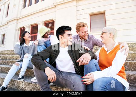 Zusammenkunft multikultureller Freunde im Urlaub in der Stadt. Leute zur freien Verfügung an einem Frühlingstag. Stockfoto