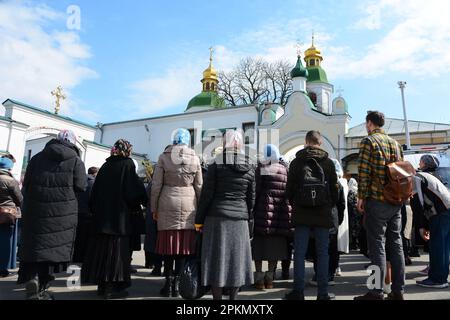 Eine gläubige Frau der ukrainisch-orthodoxen Kirche, die der Aufrechterhaltung von Verbindungen zu Moskau beschuldigt wird, betet, während sie vor dem historischen Kloster Kiew-Pechersk Lavra ein Kreuz hält, um den Eintritt der kommission des Kulturministeriums zu verhindern, die mit der Übertragung der Lavra an den Staat und der Räumung ihrer Mönche beginnen sollte. Gläubige der ukrainisch-orthodoxen Kirche des Moskauer Patriarchats blockieren weiterhin den Eingang zu den Gebäuden der Kiew-Pechersk-Lavra für Vertreter der kommission des Kulturministeriums. Anfang März 2023 kündigte die Ukraine den Pachtvertrag Stockfoto