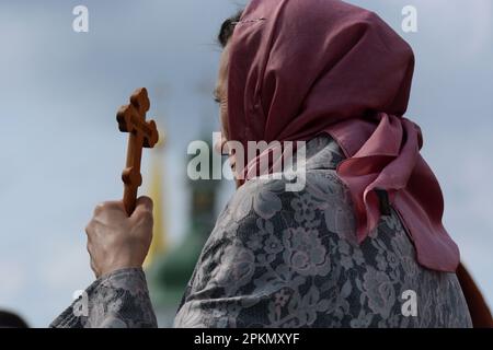 Eine gläubige Frau der ukrainisch-orthodoxen Kirche, die der Aufrechterhaltung von Verbindungen zu Moskau beschuldigt wird, betet, während sie vor dem historischen Kloster Kiew-Pechersk Lavra ein Kreuz hält, um den Eintritt der kommission des Kulturministeriums zu verhindern, die mit der Übertragung der Lavra an den Staat und der Räumung ihrer Mönche beginnen sollte. Gläubige der ukrainisch-orthodoxen Kirche des Moskauer Patriarchats blockieren weiterhin den Eingang zu den Gebäuden der Kiew-Pechersk-Lavra für Vertreter der kommission des Kulturministeriums. Anfang März 2023 kündigte die Ukraine den Pachtvertrag Stockfoto