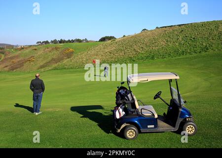 Ein paar Jungs, die versuchen, den Golfball in eines der Löcher auf dem Golfplatz in Etretat (seine-Maritime), Normandie, Frankreich zu stecken Stockfoto