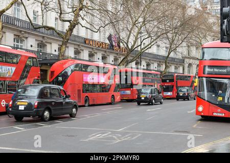 London, Großbritannien - 17. März 2023; mehrere rote Londoner Doppeldeckerbusse vor dem Waldorf Hotel mit Taxis mit Bewegungsunschärfe Stockfoto