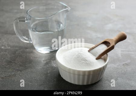 Backpulver in Schüssel auf grauem Tisch Stockfoto