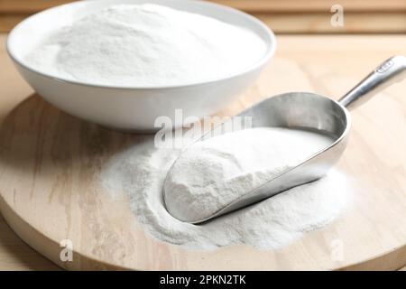 Backpulver in Schaufel und Schüssel auf Holztisch Stockfoto