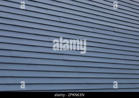 Blaue Holzverkleidung eines alten Hauses aus dem Jahr 1700er in Newport, Rhode Island. Abbildung zeigt einen größeren Teil der Außenwand. Stockfoto