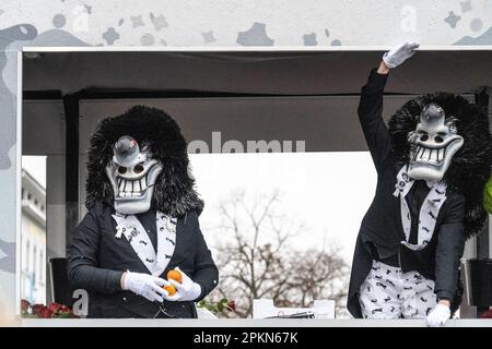 Waggis-Kostüm in einem Paradenturm, der auf dem Basler Fasnacht-Karneval in der Schweiz mit Orangen wedelt und verteilt Stockfoto