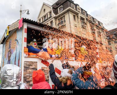 Waggis-Kostüm in einem Paradewagen, der Konfetti auf dem Basler Fasnacht-Karneval in der Schweiz wirft Stockfoto