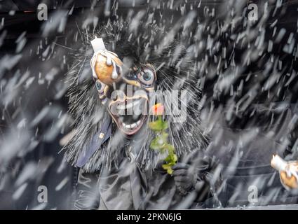 Waggis-Kostüm in einem Paradewagen, der Konfetti auf dem Basler Fasnacht-Karneval in der Schweiz wirft Stockfoto