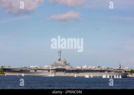 Ein Segelbootkurs vor dem historischen Flugzeugträger USS Yorktown der US Navy in Charleston Harbor, South Carolina, USA. Stockfoto