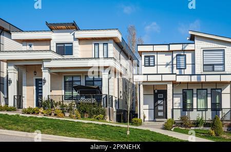 Eine perfekte Nachbarschaft. Häuser in einem Vorort am Frühling in Nordamerika. Außenfassade des Immobiliengebäudes an einem sonnigen Tag. Großer maßgeschneiderter Luxus Stockfoto