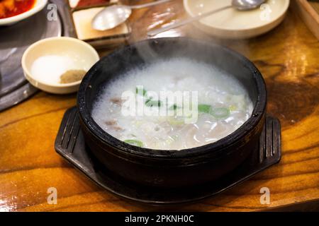 Lokale traditionelle koreanische Gourmetküche auf der Straße Schweinefleisch Rippchen Porridge Reissuppe mit Beilagen Würzmittel für koreanische Reisende besuchen A Stockfoto